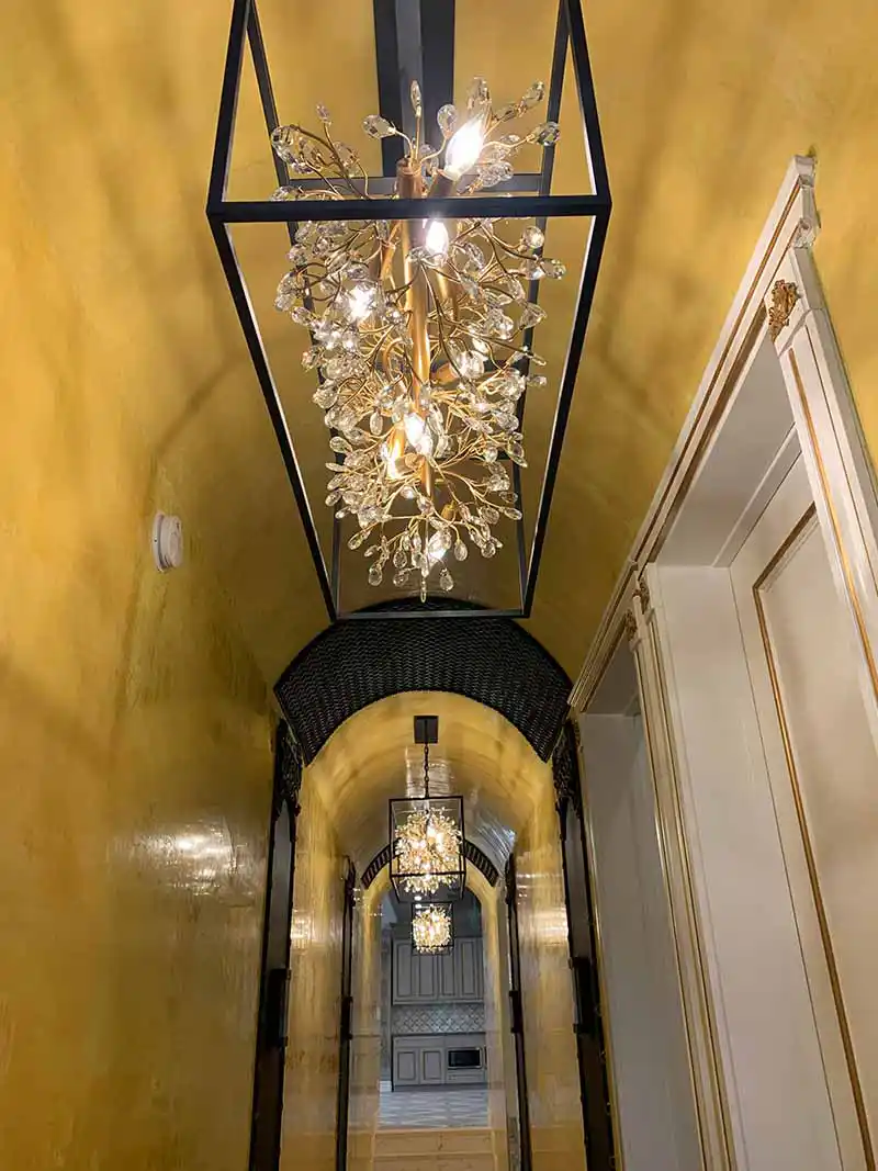 Luxury hallway chandelier lighting installation in high-end residence in Los Angeles
